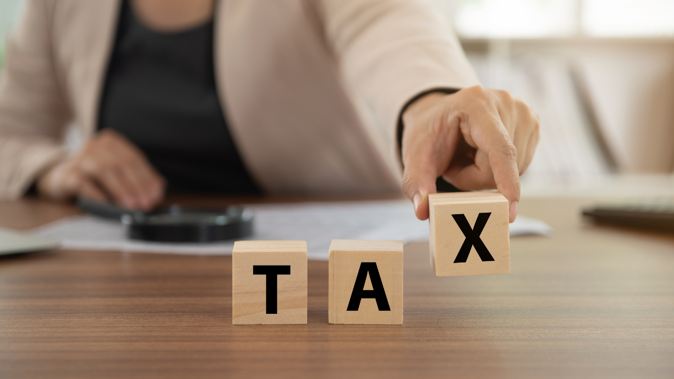 New Tax Laws for 2024: What Business Owners Need to Know a woman is holding a wooden block with the word tax tax written on it