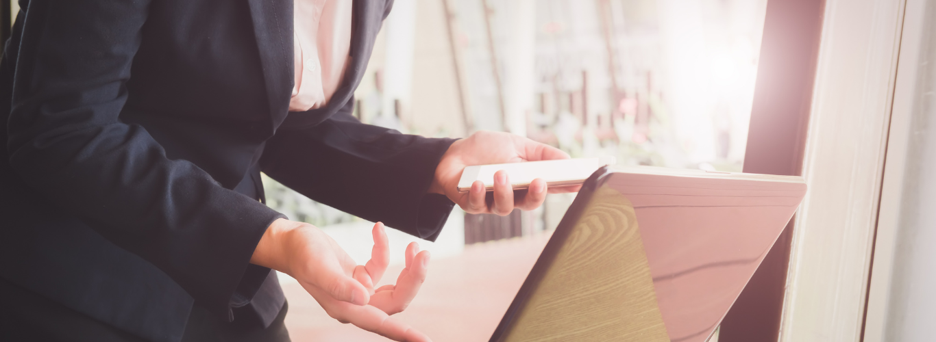 Why You Need a Bookkeeper Even If You're Using Accounting Software suit holding phone looking at computer